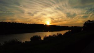 Zonsondergang boven de Maas, een rivier vol verhalen en natuurlijke schoonheid in Nederland